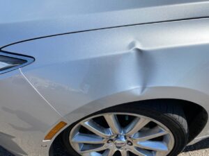 picture of a dent on a fender of a lincoln that can have the process of paintless dent repair applied to it