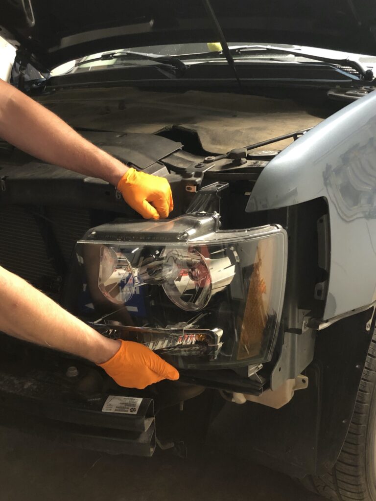 headlight being removed for access behind the fender of car to begin the paintless dent removal process
