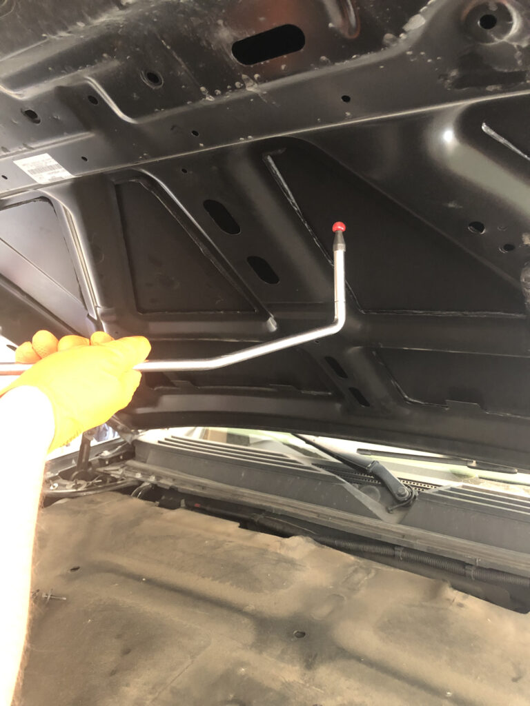 owner showing what paintless dent repair tool that would be used to remove a dent on a hood of a auto